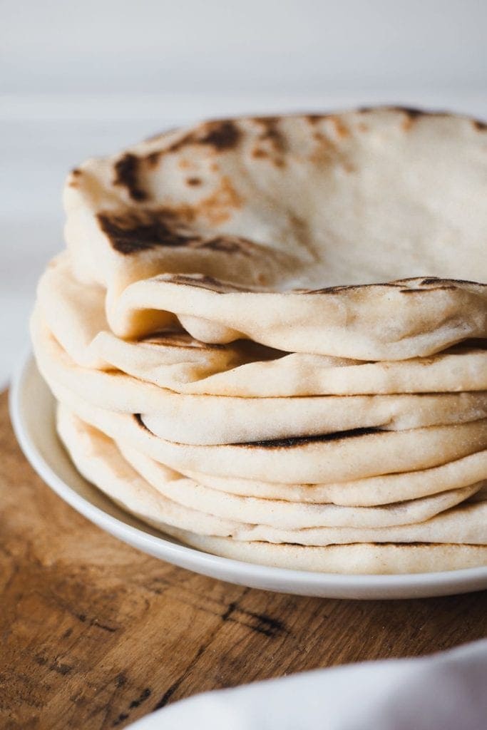 El Bazlama es un increíble y delicioso pan plano turco, suave y acolchado! Es extra tierno y hueco, un mix perfecto entre el pan Naan y el pan Pita. Sírvelo con tus salsas favoritas, carne asada, hummus o disfrútalo solo tal cual. Foto en ángulo y de cerca para poder apreciar lo esponjoso que es este pan.