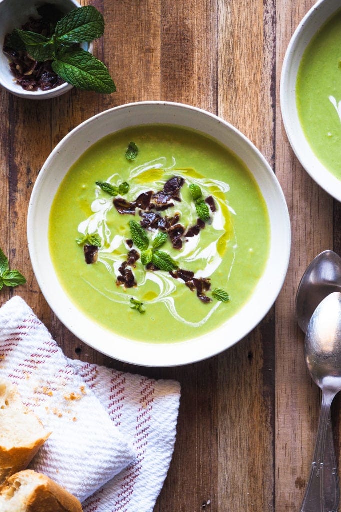 This 20 Minute Pea Soup with Serrano Ham is so easy and quick to put together while being very tasty. It's fresh, light and healthy, plus great for making the most of seasonal peas, although you can also make it with frozen peas. The kefir, mint and Serrano ham topping take it up a notch, making it and ideal starter for a meal with family and friends | Paula's Apron Recipe