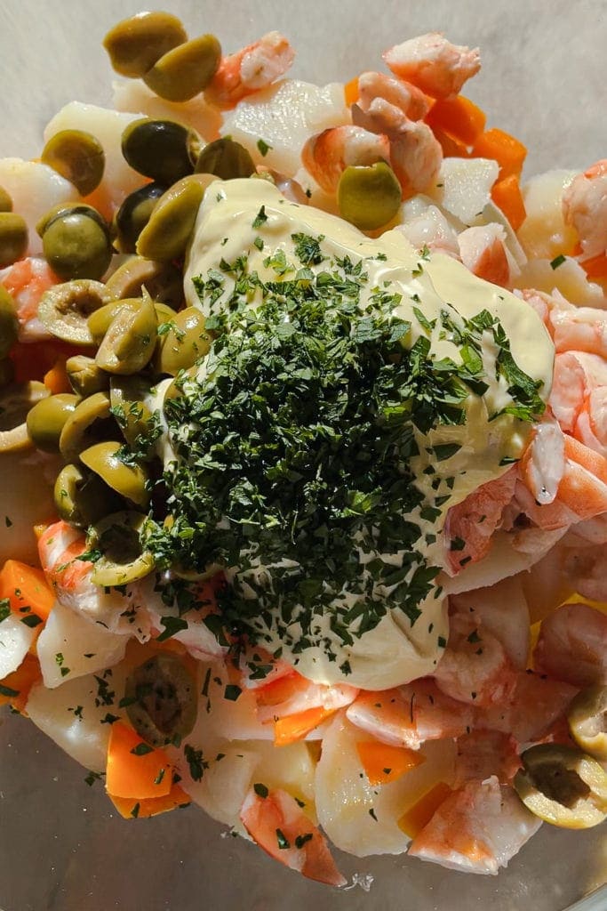 Esta Ensalada de Patata y Langostinos es una receta de mi abuela. Lleva patata, zanahoria, aceitunas verdes y langostinos cortados a trozos, aliñado todo con mayonesa casera y un toque de perejil fresco picado. Es cremosa y llena sin ser pesada, saludable y deliciosa. Vamos, una ensalada imprescindible de verano que ¡además puedes preparar con antelación! | Receta de Paula's Apron