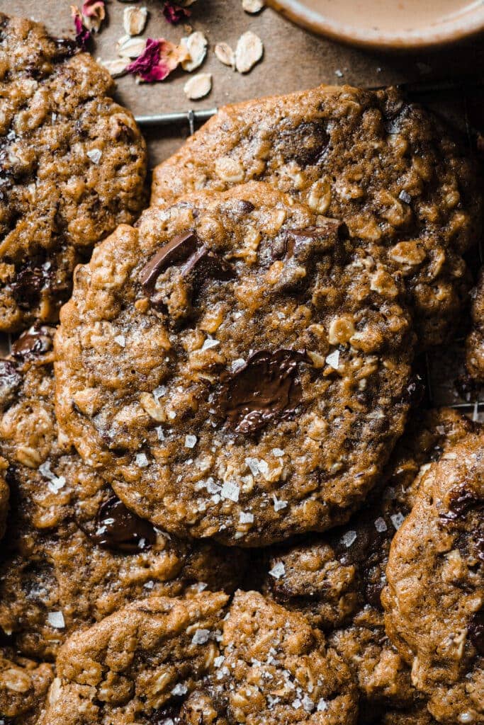 Estas Cookies de Avena y Chocolate con Mantequilla Tostada son una variación deliciosa de las clásicas cookies americanas. El toque de la avena aporta textura y lo que las hace aún más increíbles es el toque de mantequilla tostada con su aroma a frutos secos tostados. Quedan crujientes por fuera y blanditas por el centro, como una buena cookie (por eso no la llamo galleta como tal), y personalmente me encantan con un toque final de sal marina para ese contraste dulce-salado. | Receta de Paula's Apron