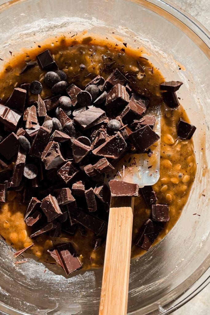 Brown Butter Oatmeal Chocolate Chip Cookies dough in a bowl with chocolate chunks on the top not mixed in yet. | Paula's Apron Recipe