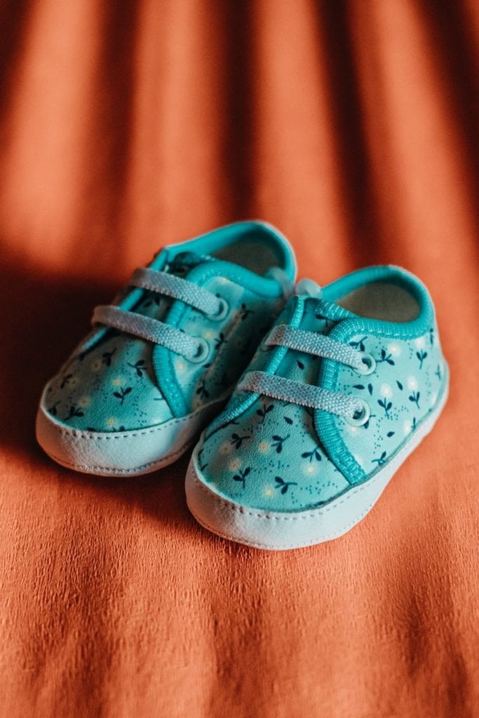 a pair of blue shoes sitting on top of a bed