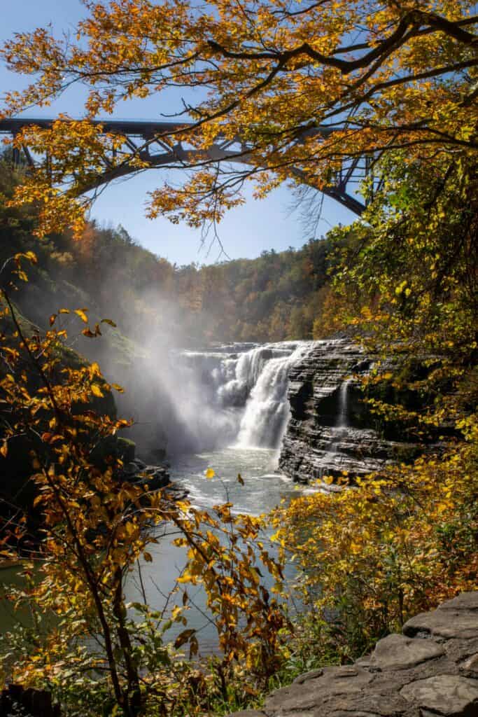 Breathtaking view of a waterfall framed by autumn leaves in Letchworth State Park, New York.