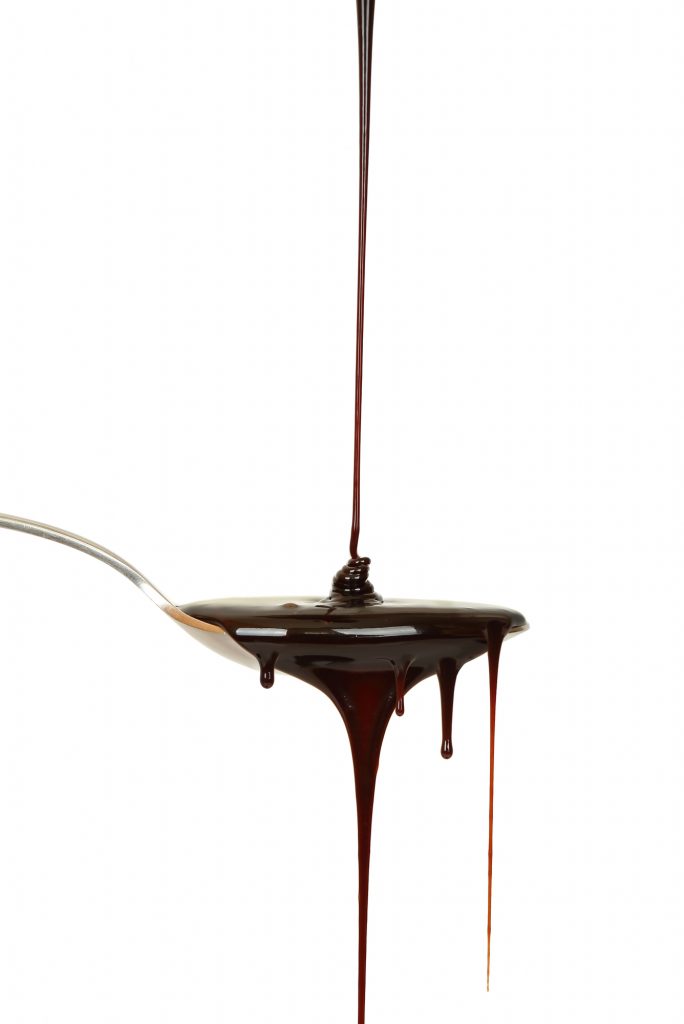 chocolate syrup dripping from a spoon