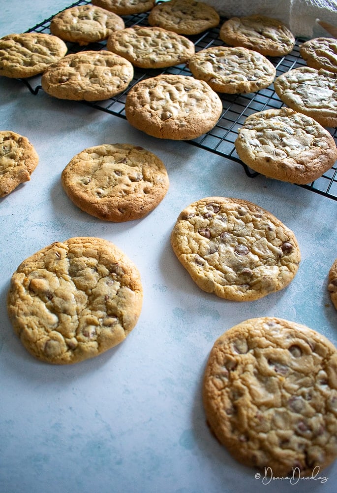 3/4 shot of cookies on wire rack, others on table in foreground