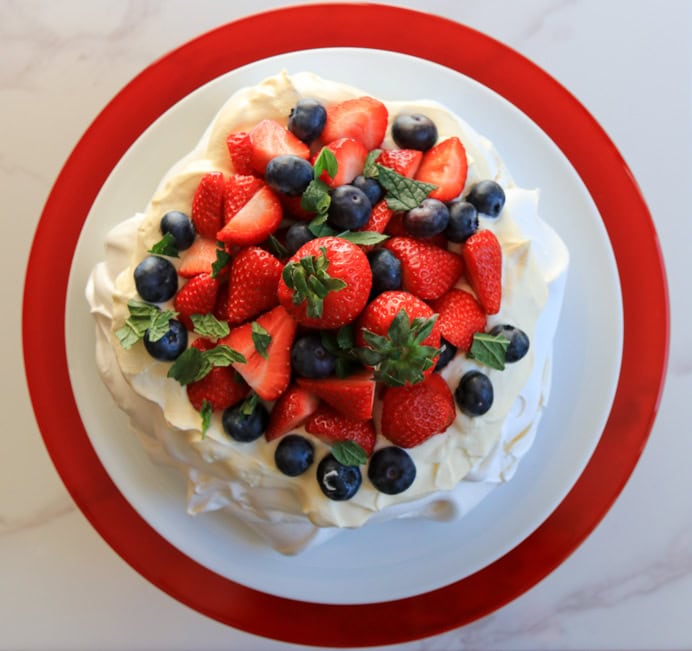 Pavlova recipe with whipped cream, strawberries and raspberry coulis