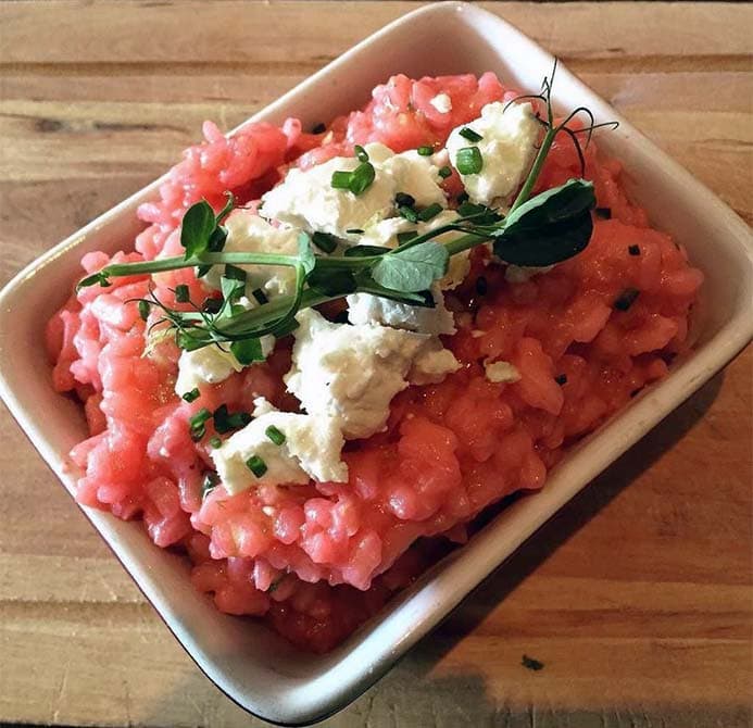 A dish of beetroot risotto and goat's cheese.