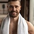 Crop smiling sportsman with towel after workout in gym
