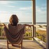 young woman relaxing on the porch of a beach house - HQ stock picture