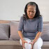 Elderly woman massaging the knee easing the aches. Joint pain concept.