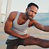 Young bearded male fit athlete doing warm-up, stretching his arms before training