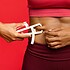 Woman measuring her body fat with body fat caliper