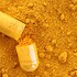 Curcumin capsule with pile of turmeric