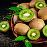 Fresh kiwi with leaves on a wooden plate.