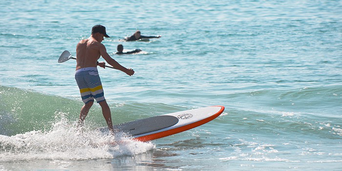 Epoxy paddle board being used for surfing