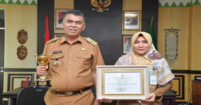 Bupati Natuna Wan Siswandi dan Kepala Dinas P3AP2KB Natuna, Sri Riawati Saat Memegang Piala dan Penghargaan APE 2021