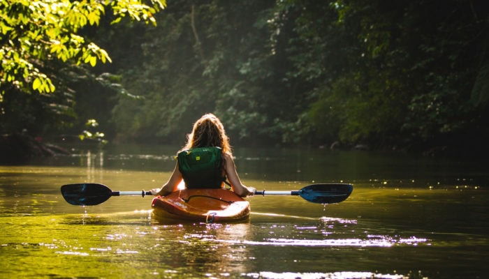 Person using a dry bag backpack on a kayak