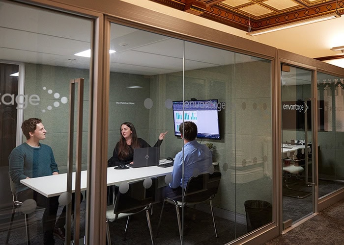 Three professional office workers in a meeting room