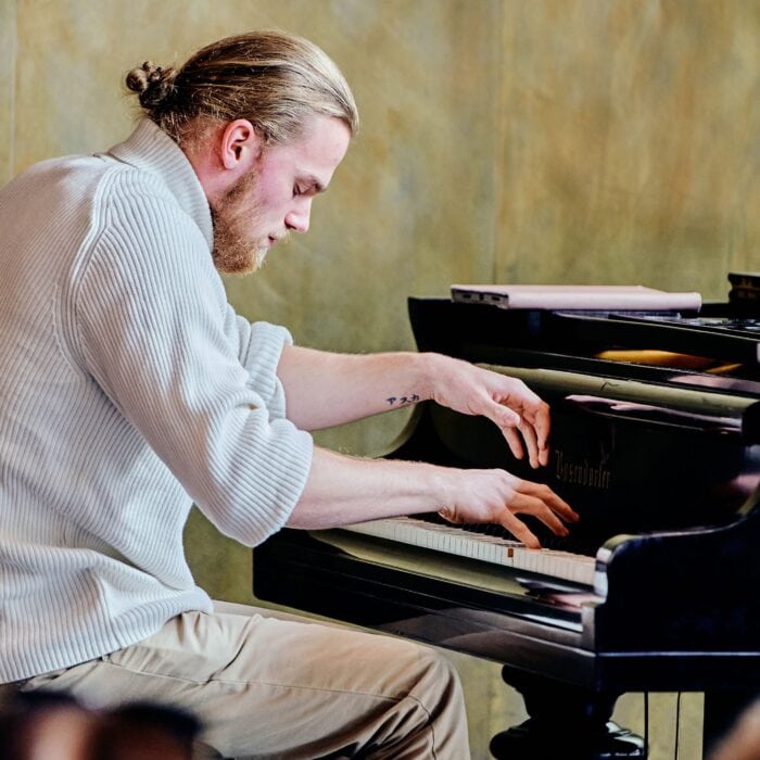 Ein Pianist ist versunken in sein Klavierspiel.