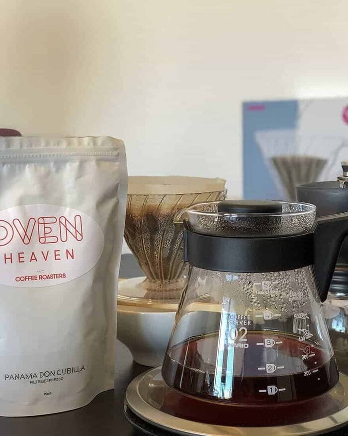 Hario V60 Kit para preparar café de filtro encima de una báscula con bolsa de café de especialidad y molinillo.