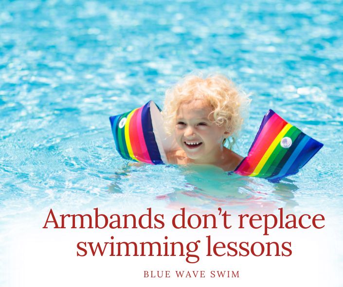 a child is swimming in a pool with armbands