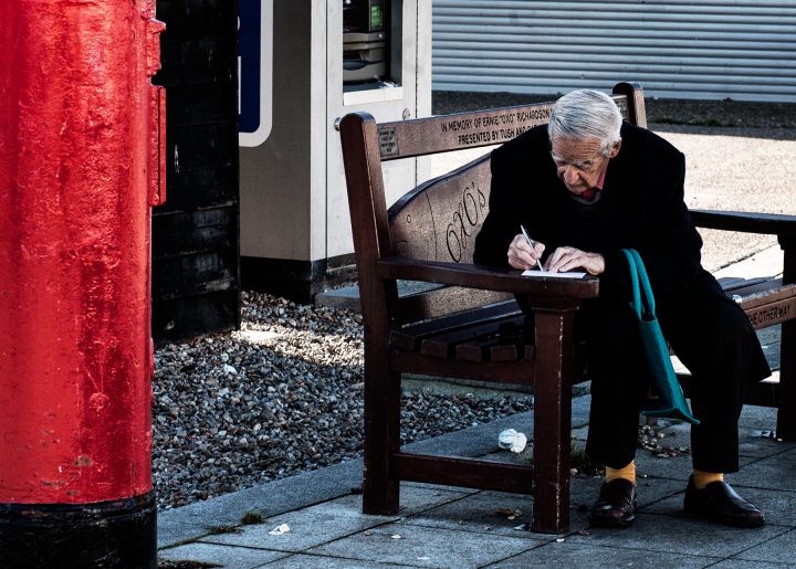 man writing postcard the stade hastings