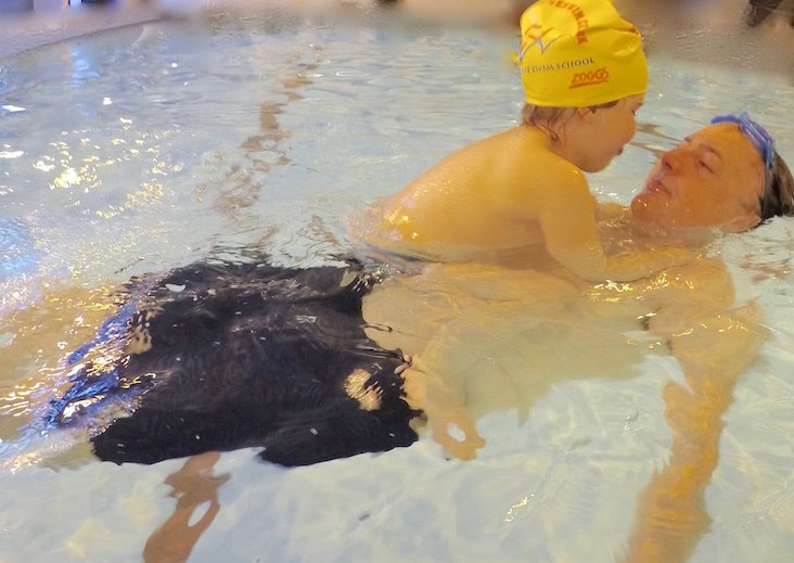A father and daughter swimming together and relaxing in water