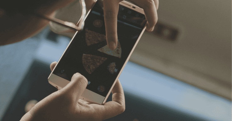 business takes instagram photo of pizza