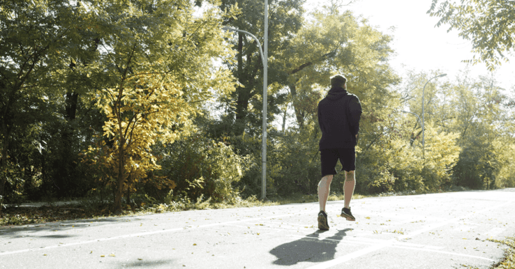 man runs down the road trying to keep up with group