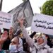 Moroccans raise placards as they gather in front of parliament in the capital Rabat to protest against rising prices, on February 20, 2022. (AFP)