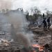 People gather at the site of an explosion at an illegal oil bunkering site in the Egbema local government area, Imo state, in southeastern Nigeria, April 24, 2022.