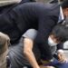 Tetsuya Yamagami wrestled down by security guard