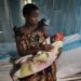 Angela, 15, holds her newborn baby girl in a hospital in Tanzania. Unmarried and living with her parents, she hopes to continue with her studies and one day become a nurse. Shinyanga, Tanzania. August 4, 2014.