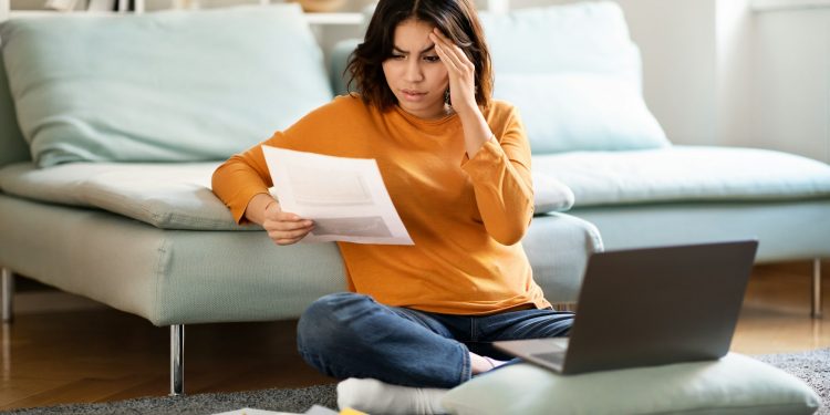 Stressed Arab Female Freelancer Working With Papers And Laptop At Home