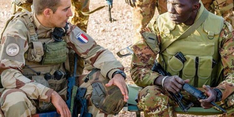 A soldier from the Malian Forces (FAMA) speaks with a soldier from the French Operation Barkhane mission (left) during a joint tactical coordination operation, in a file photo.