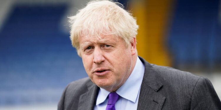British Prime Minister Boris Johnson looks on during a visit to Bury FC at their ground in Gigg Lane, Bury, Greater Manchester, Britain April 25, 2022. Danny Lawson/Pool via REUTERS