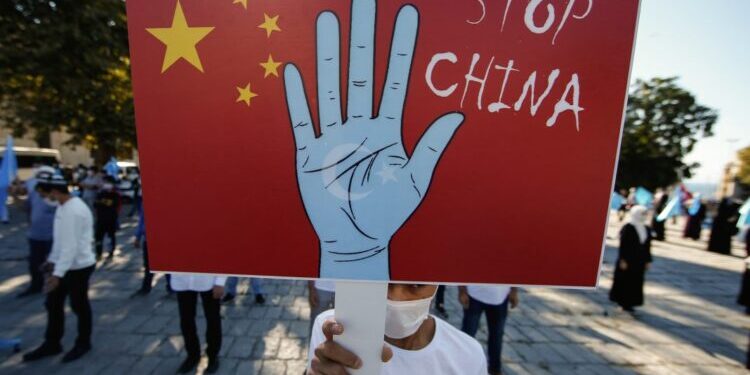 A Uyghur protester holds a sign October 1 during a demonstration in Istanbul, Turkey. (© Emrah Gurel/AP Images)