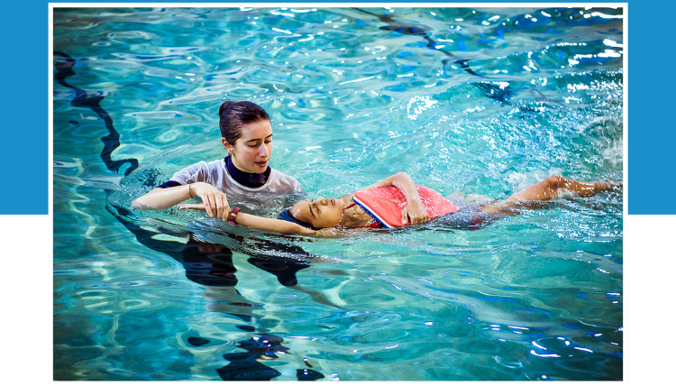 a child is swimming is in a swimming pool in Wimbledon in 1:1 swim lessons with one swim teacher.
