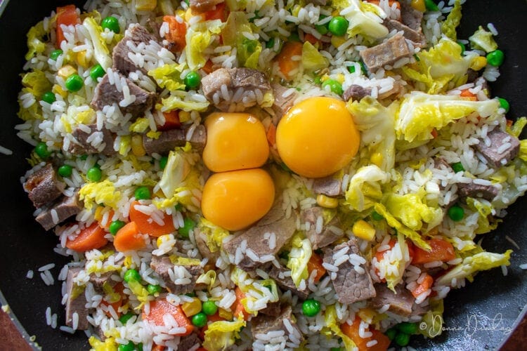 3 Eggs cracked into fried rice.