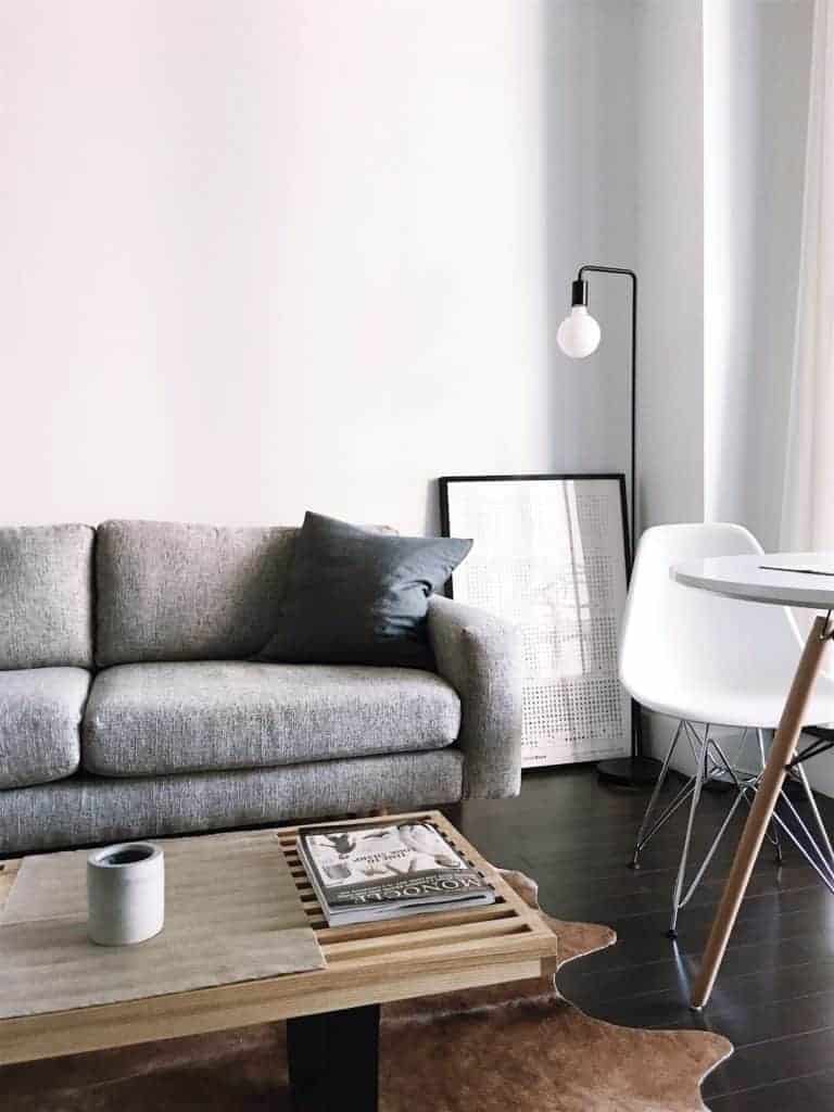 Little Spaces - Light grey sofa and wood coffee table on a dark wood floor in a small room.
