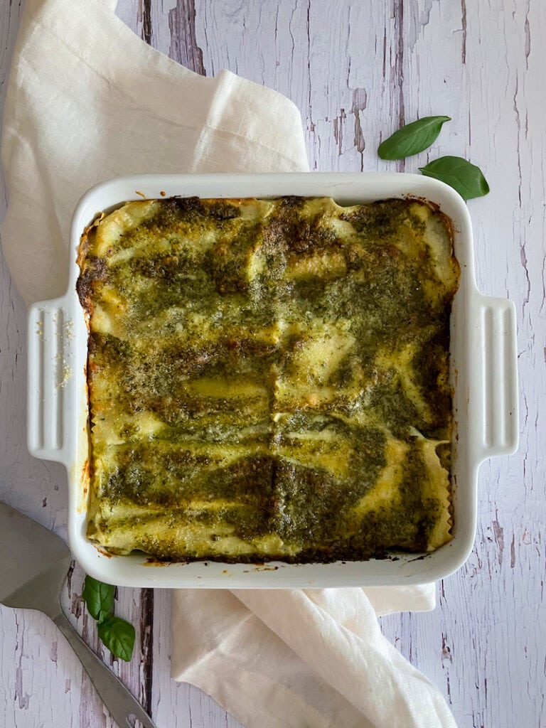 baking pan of lasagna roll ups with pesto on wooden table