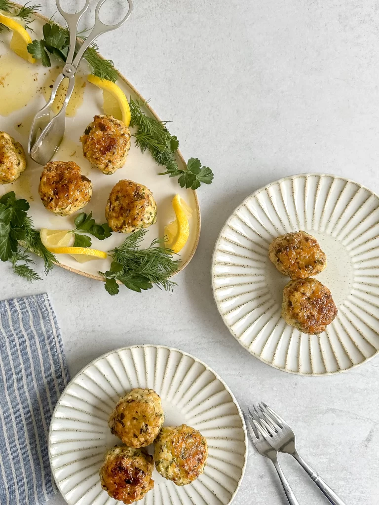 Plates with tray on a table filled with chicken meatballs.