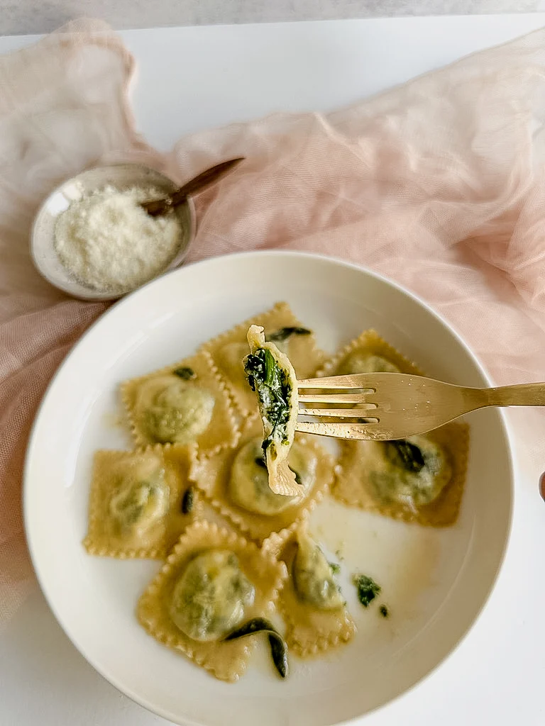 Bite of ravioli on a golden fork