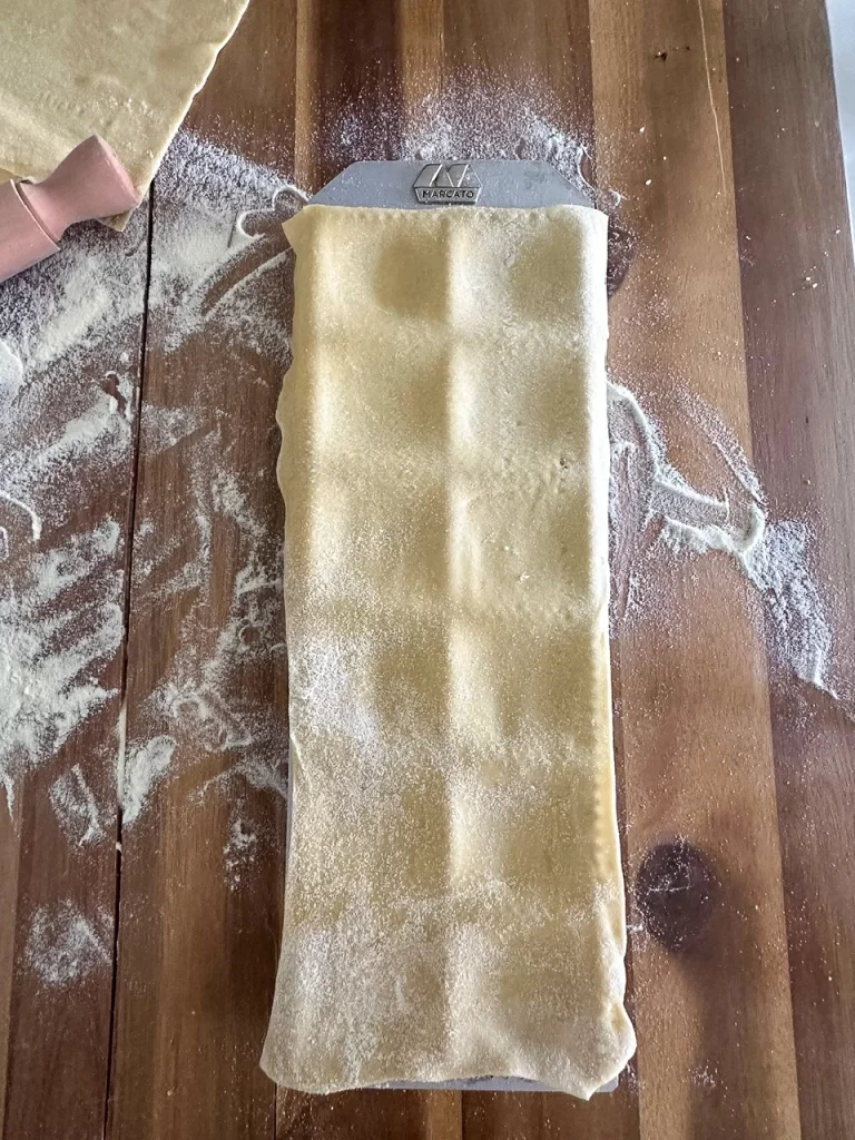 Sheet of fresh pasta over ravioli mold