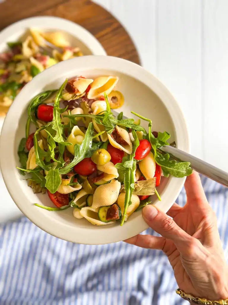 Italian Pasta Salad in a small plate in hand