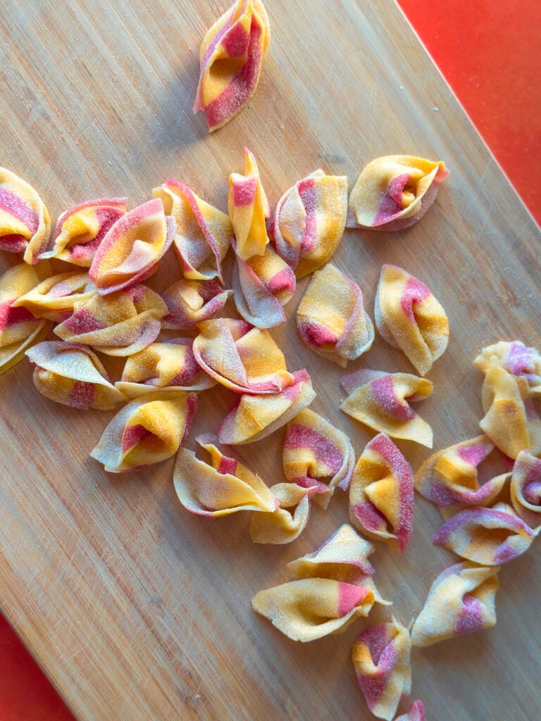 Colored striped sorpresine pasta- little surprises on a wood board