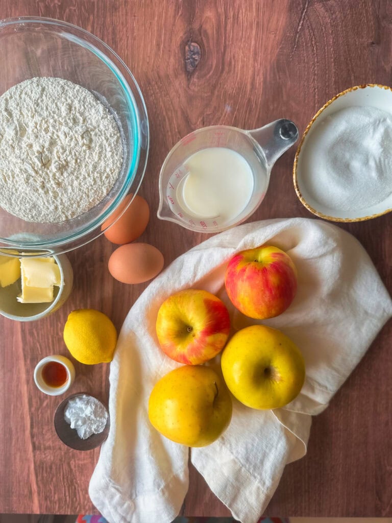 Ingredients for apple cake on a wood table