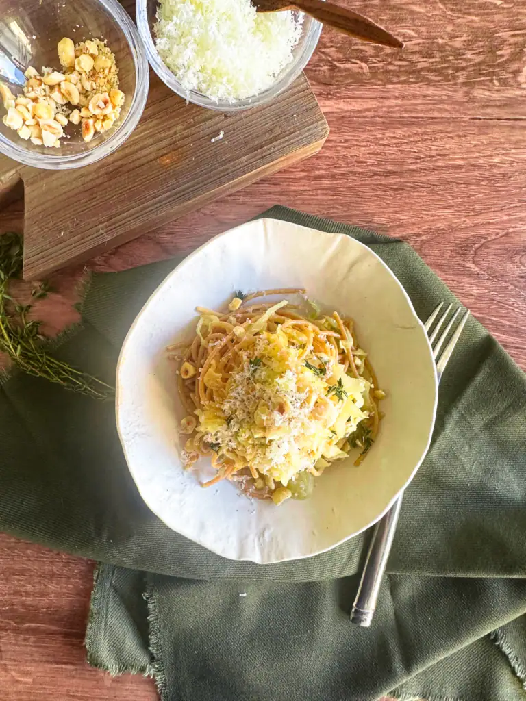 Bowl of pasta woth side of extra hazelnuts and Pecorino.