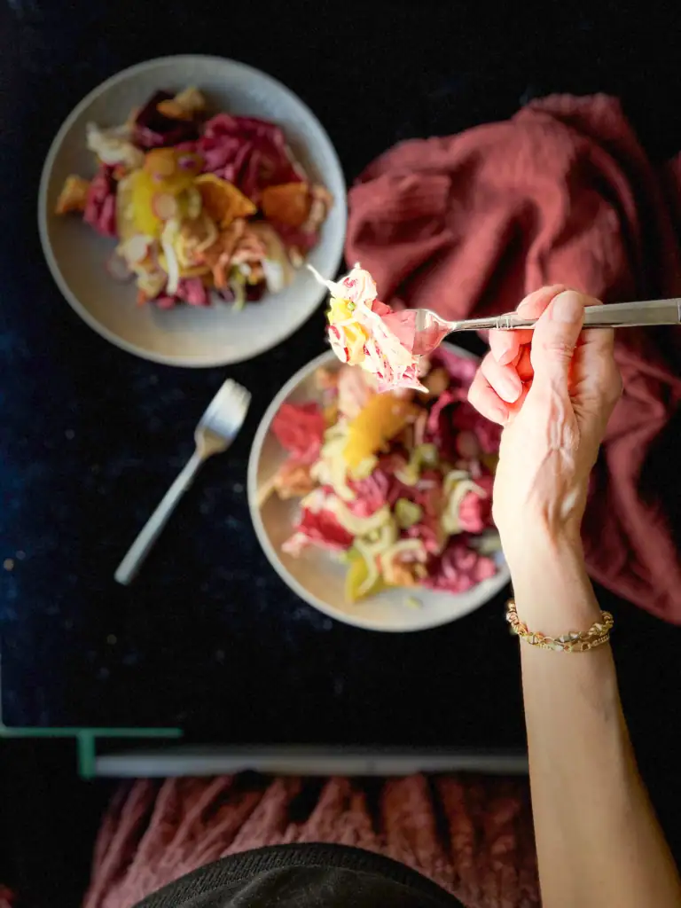 Woman seated at a table eating the salad