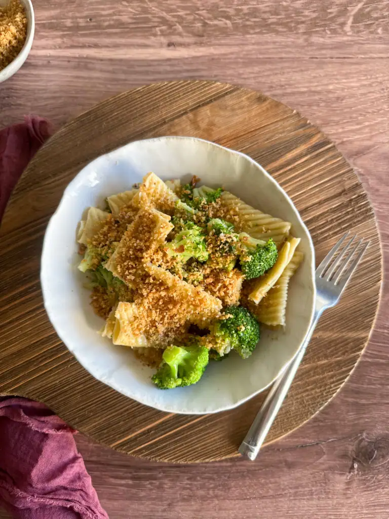 Bowl of Italian broccoli pasta over a wooden board
